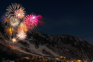 Feuerwerk über einer winterlichen Berglandschaft.