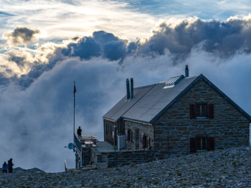 Berg- oder Schutzhütte in den Alpen mit Blick ins Tal